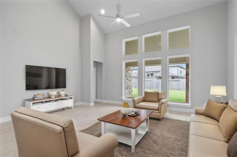 Gather the family and guests together in your lovely living room! Featuring high ceilings, recessed lighting, ceiling fan, custom paint, gorgeous floors and large windows that provide plenty of natural lighting throughout the day.