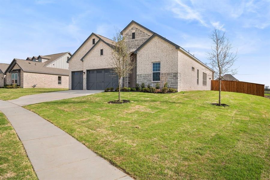 View of front of property featuring a front yard and a garage