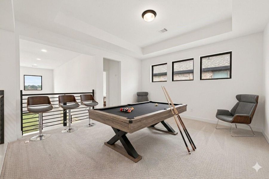 This photo showcases a bright, modern game room with a pool table, bar stools, and ample natural light from multiple windows. Perfect for entertaining and relaxation. Photos have been virtually staged to help illustrate the potential of the space.