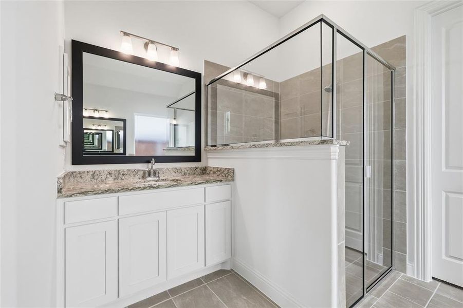 Full bathroom with vanity, a stall shower, and light tile patterned floors Full bathroom with vanity, a stall shower, and light tile patterned floors