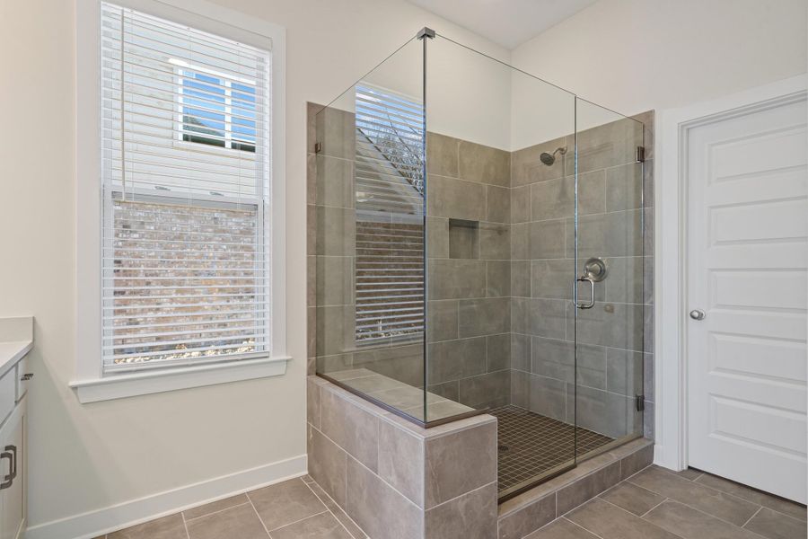 Bathroom featuring vanity, a stall shower, and light tile patterned flooring