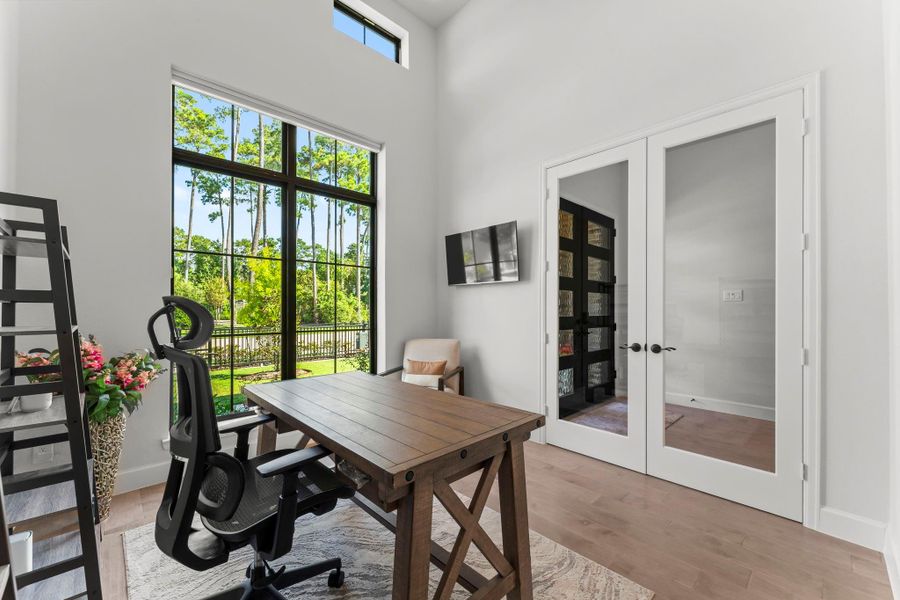 An office or study is shown in this photo. The room has high ceilings and a large window that overlooks the front yard and surrounding trees. The room also has french doors with frosted glass panels. An office or study is shown in this photo. The room has high ceilings and a large window that overlooks the front yard and surrounding trees. The room also has french doors with frosted glass panels.