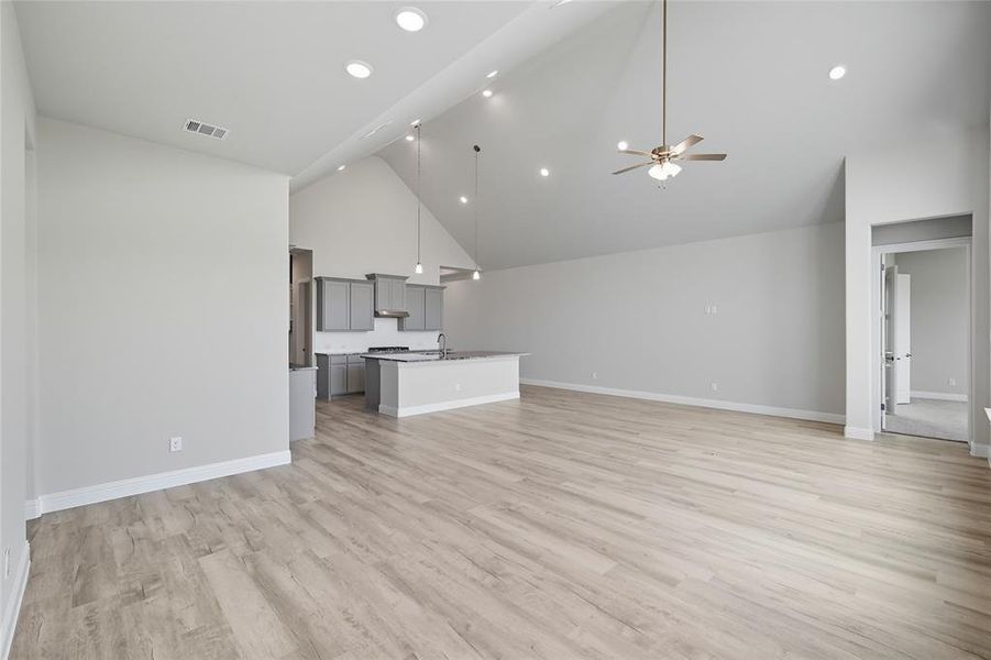 Unfurnished living room with ceiling fan, light wood-style floors, lofted ceiling, and recessed lighting