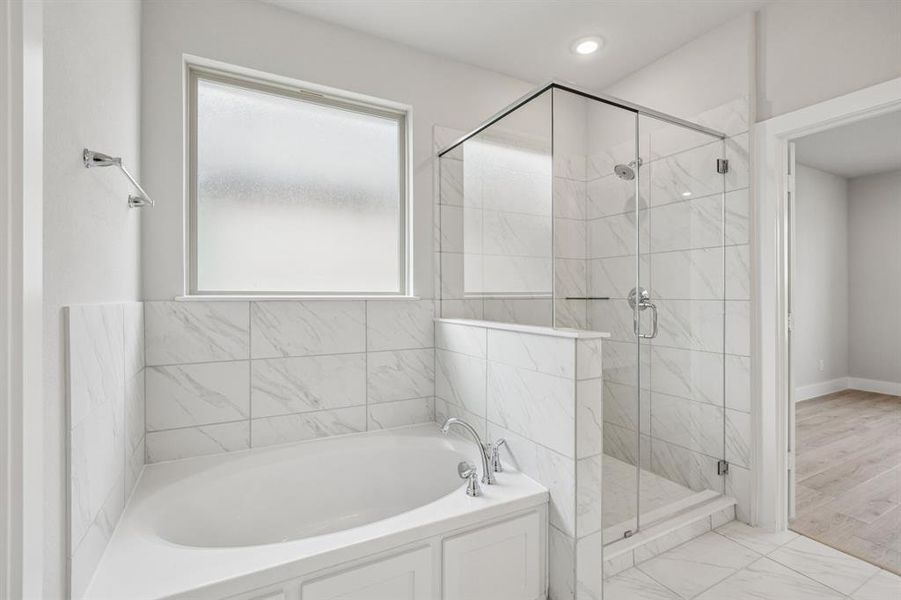 Bathroom with a garden tub, a marble finish shower, marble finish floors, and recessed lighting Bathroom with a garden tub, a marble finish shower, marble finish floors, and recessed lighting