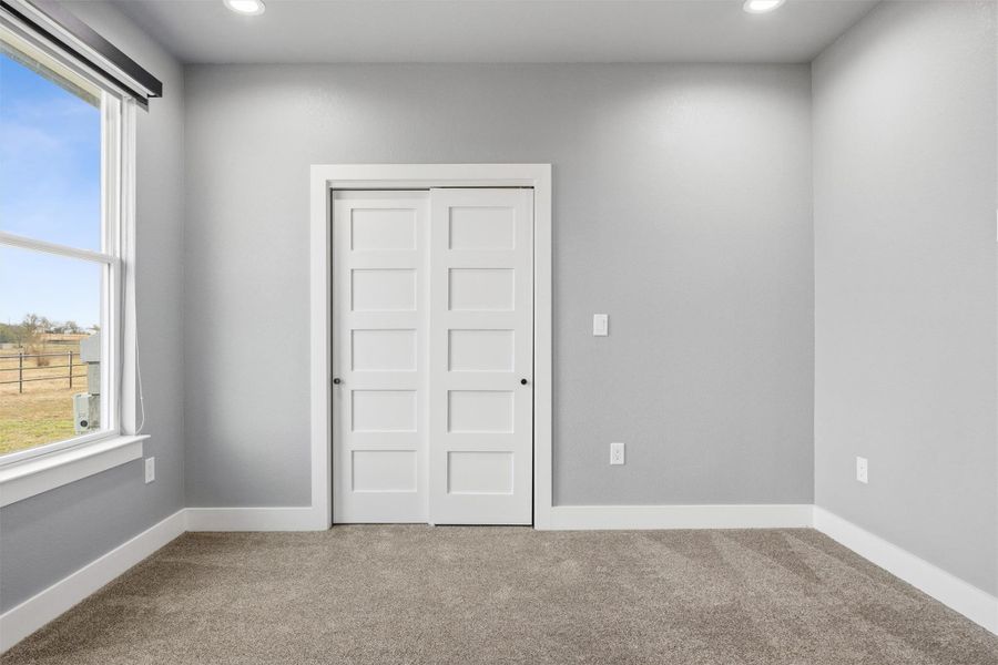 Unfurnished bedroom with carpet flooring, a closet, and recessed lighting