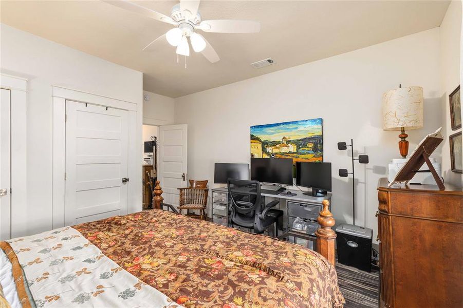 Bedroom featuring a ceiling fan, white paneled doors, and light-colored walls