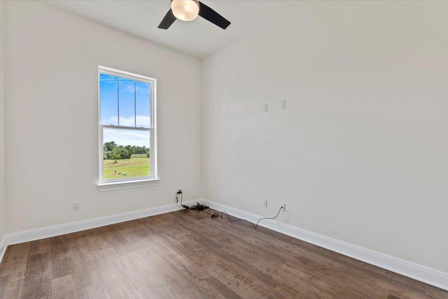Unfurnished room with wood finished floors and a ceiling fan
