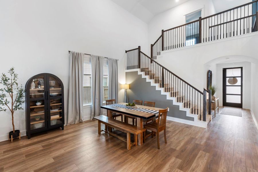 Another view of the dining area with  large windows with light curtains, adding a cozy touch.
