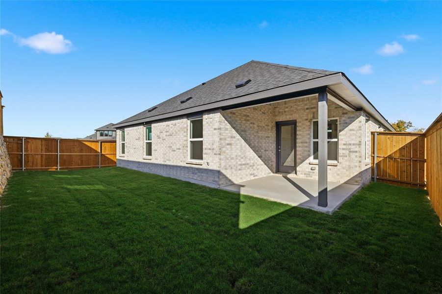 Rear view of property with a fenced backyard, brick siding, a patio, and roof with shingles Rear view of property with a fenced backyard, brick siding, a patio, and roof with shingles