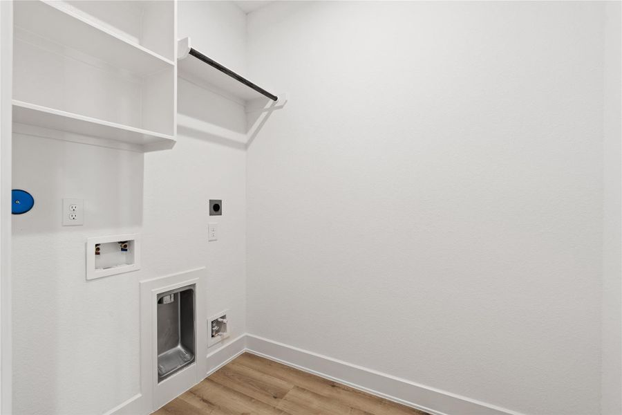 The dedicated laundry roompairs practicality with polish —complete with built-in shelvingand easy access flow.