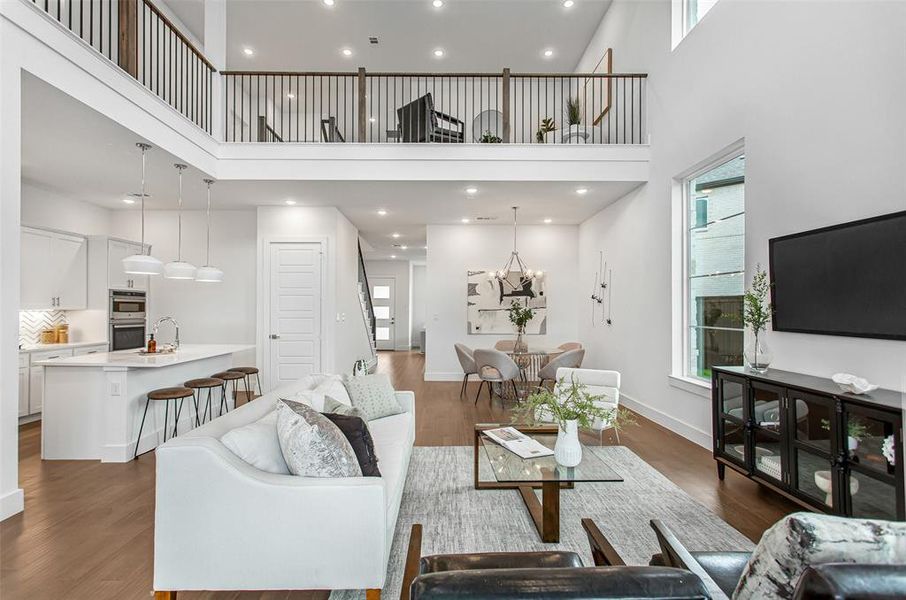 Living room featuring a towering ceiling, dark wood-type flooring, and a notable chandelier