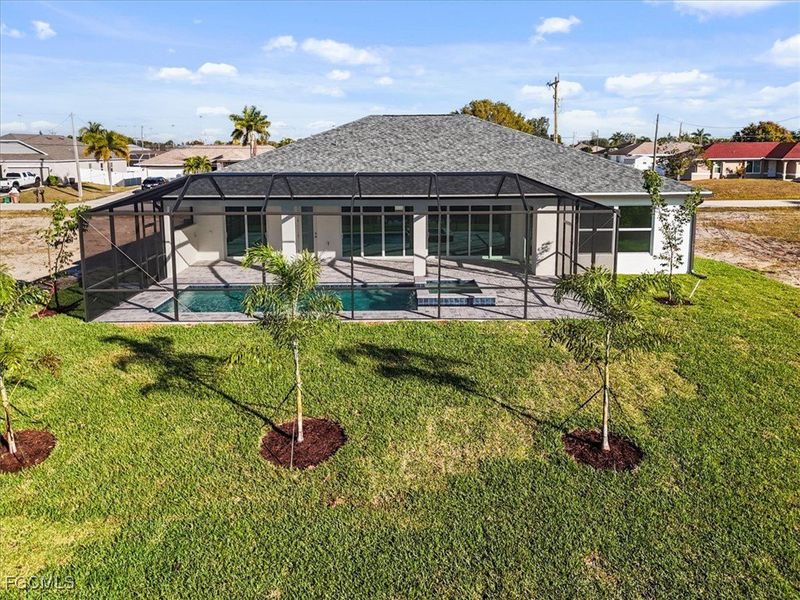 Back of house with a sunroom, an outdoor pool, and glass enclosure Back of house with a sunroom, an outdoor pool, and glass enclosure
