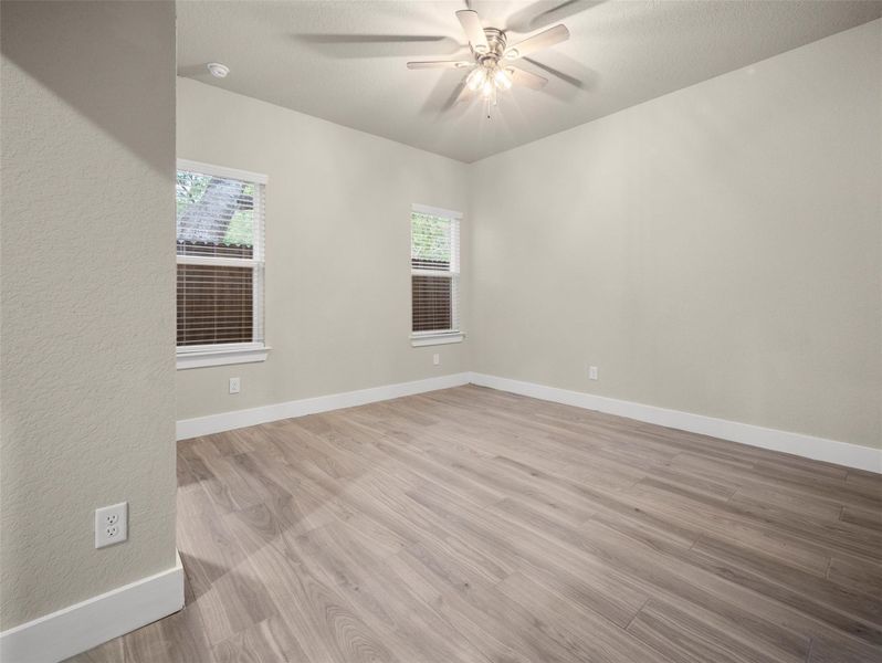 Spare room featuring light wood-style flooring, a textured ceiling, and a ceiling fan Spare room featuring light wood-style flooring, a textured ceiling, and a ceiling fan