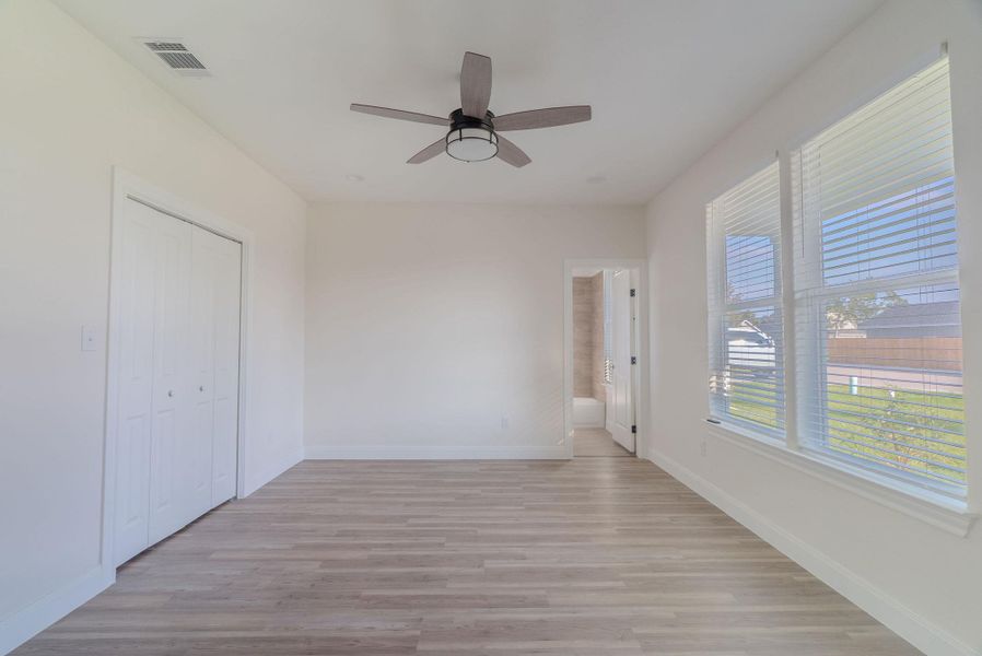 Unfurnished bedroom featuring light wood finished floors, a closet, connected bathroom, and a ceiling fan Unfurnished bedroom featuring light wood finished floors, a closet, connected bathroom, and a ceiling fan