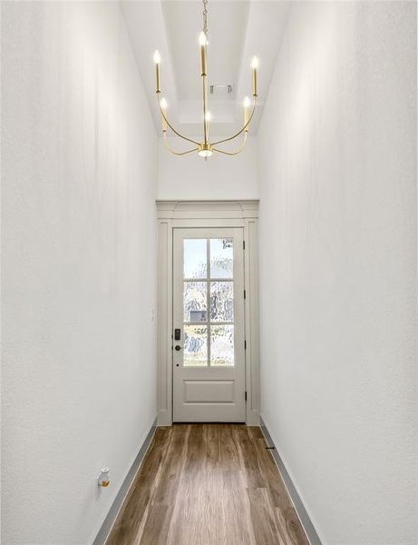 Doorway featuring a chandelier and wood finished floors
