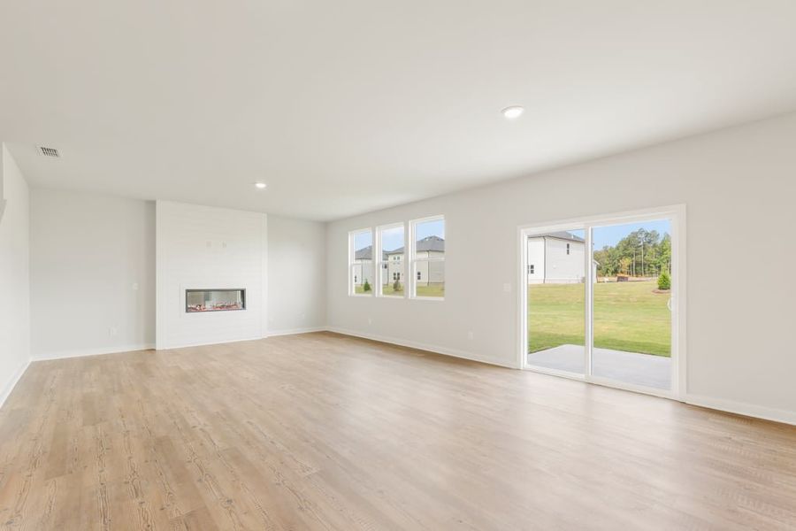 A room with a wood floor and a wood floor with a large window. A room with a wood floor and a wood floor with a large window.