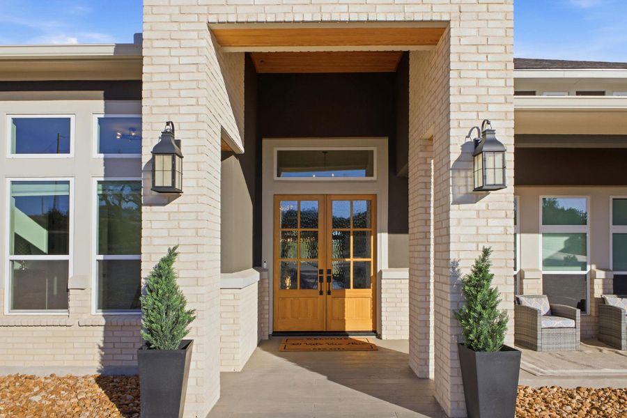 The property features a brick exterior with a prominent front entrance, including double wooden doors with glass panels