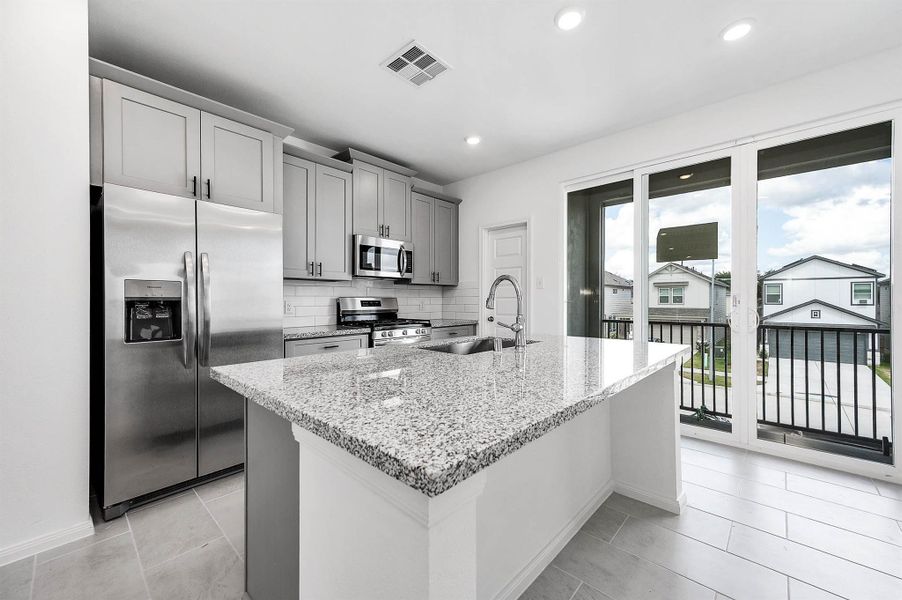 Bright and open, the kitchen featuring a spacious center island with a breakfast bar, ideal for everyday dining and entertaining. Bright and open, the kitchen featuring a spacious center island with a breakfast bar, ideal for everyday dining and entertaining.
