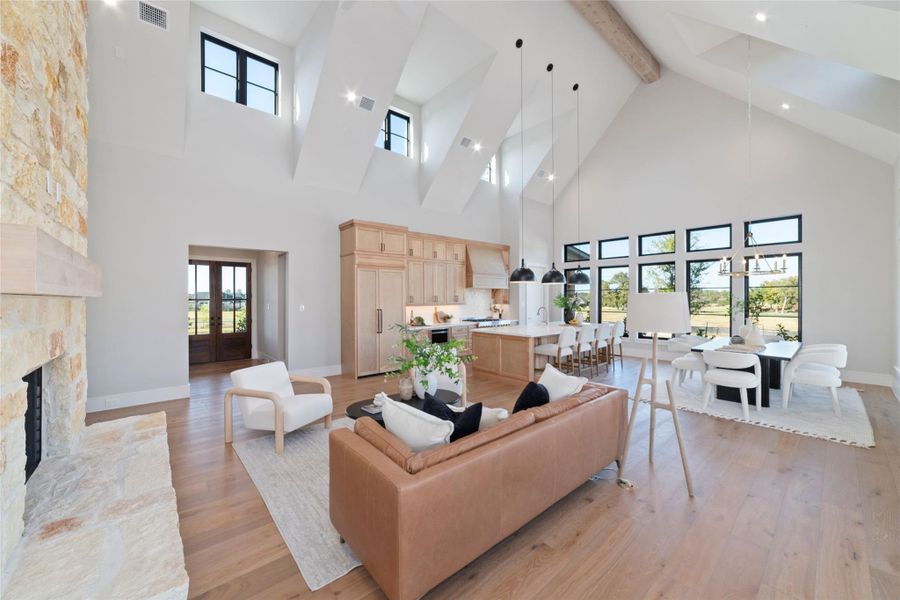 Open concept living room with views of the backyard through large picture windows.