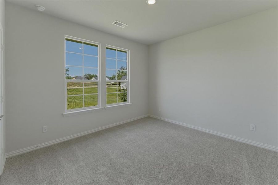 Bright room featuring two large windows, neutral gray carpeting, white baseboards, and recessed ceiling lighting