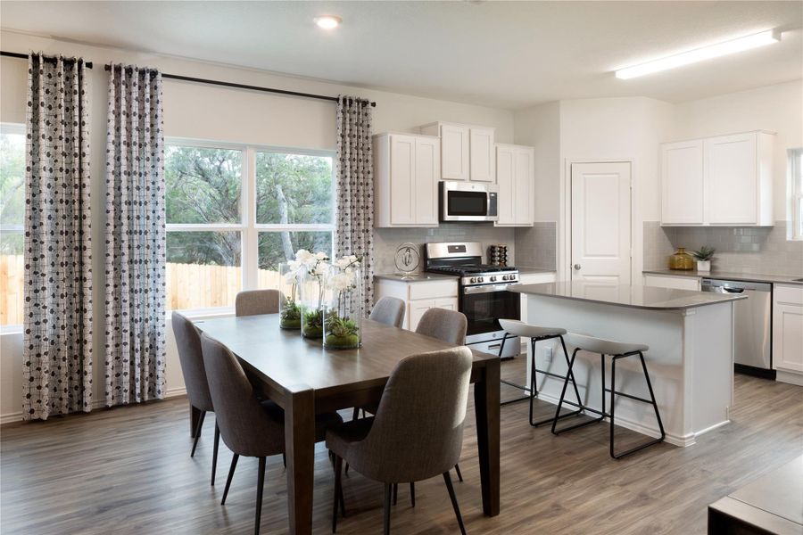 Dining room with light wood-style floors and recessed lighting