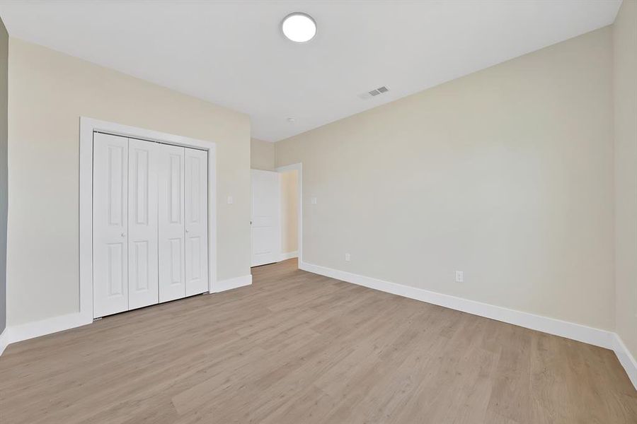 Unfurnished bedroom with light wood-style flooring and a closet