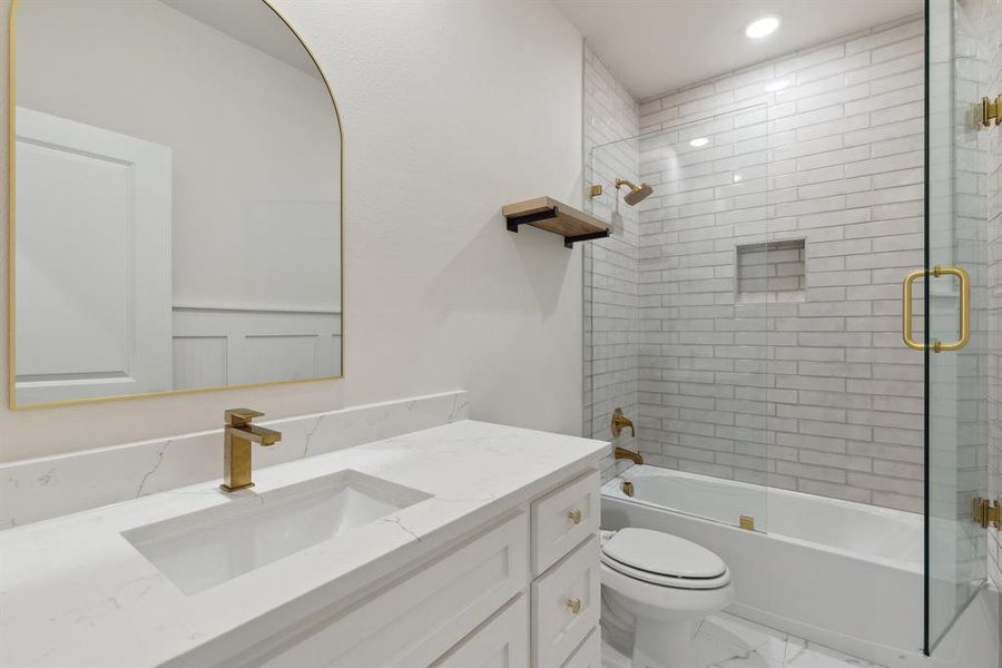 Bathroom featuring shower / bath combination with glass door, vanity, recessed lighting, toilet, and marble finish floor