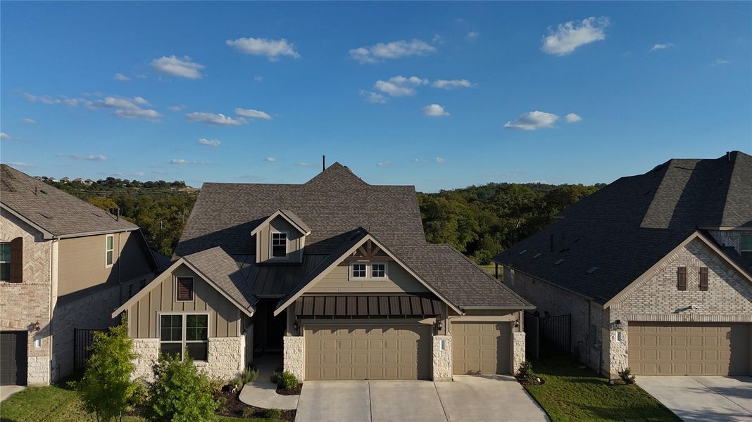 View of front of home featuring a standing seam roof, board and batten siding, a metal roof, concrete driveway, and stone siding View of front of home featuring a standing seam roof, board and batten siding, a metal roof, concrete driveway, and stone siding