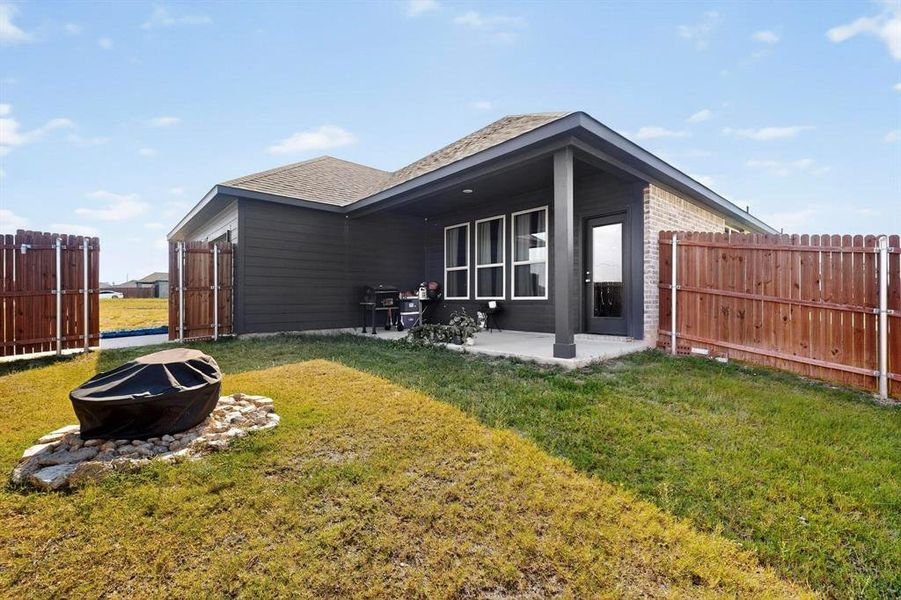 View of side of home with a patio, a fenced backyard, an outdoor fire pit, and brick siding View of side of home with a patio, a fenced backyard, an outdoor fire pit, and brick siding