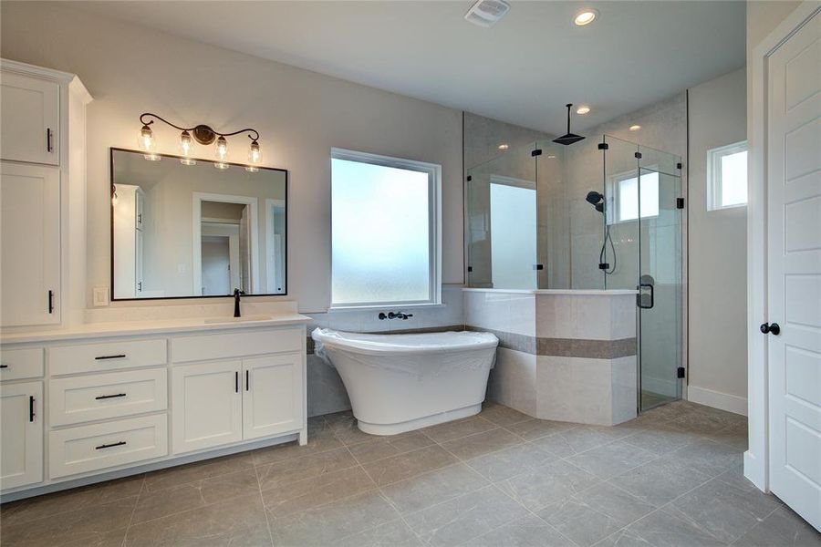 Bathroom with tile floors, separate shower and tub, and vanity