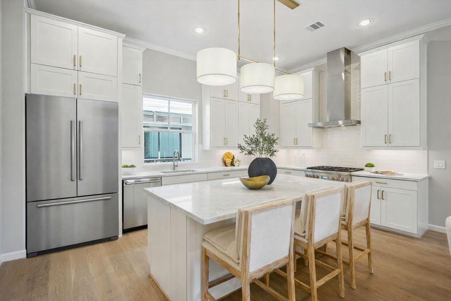 Kitchen has porcelain backsplash, gold island pendant light, and engineered white oak wood flooring (fridge is not included).