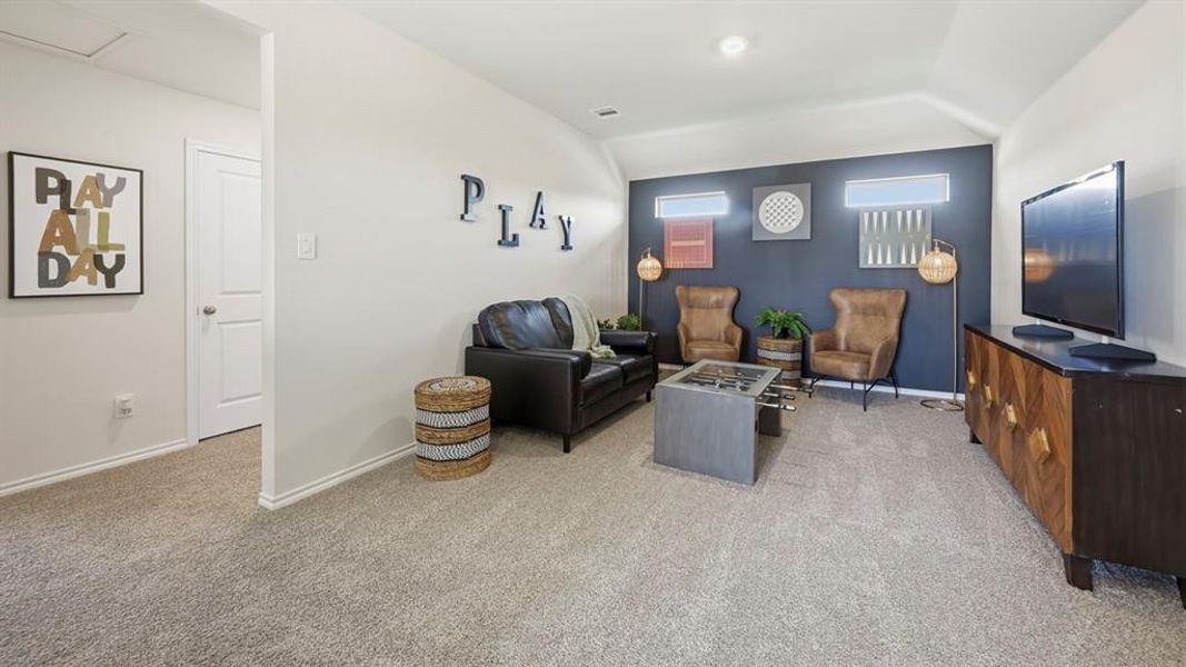 Living area featuring light carpet and vaulted ceiling Living area featuring light carpet and vaulted ceiling
