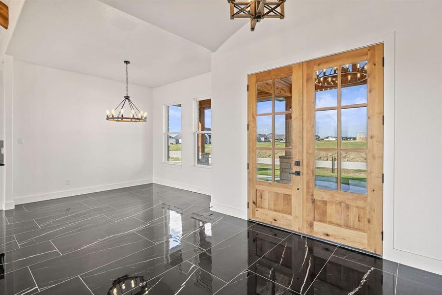 Foyer featuring a chandelier, baseboards, french doors, and vaulted ceiling Foyer featuring a chandelier, baseboards, french doors, and vaulted ceiling