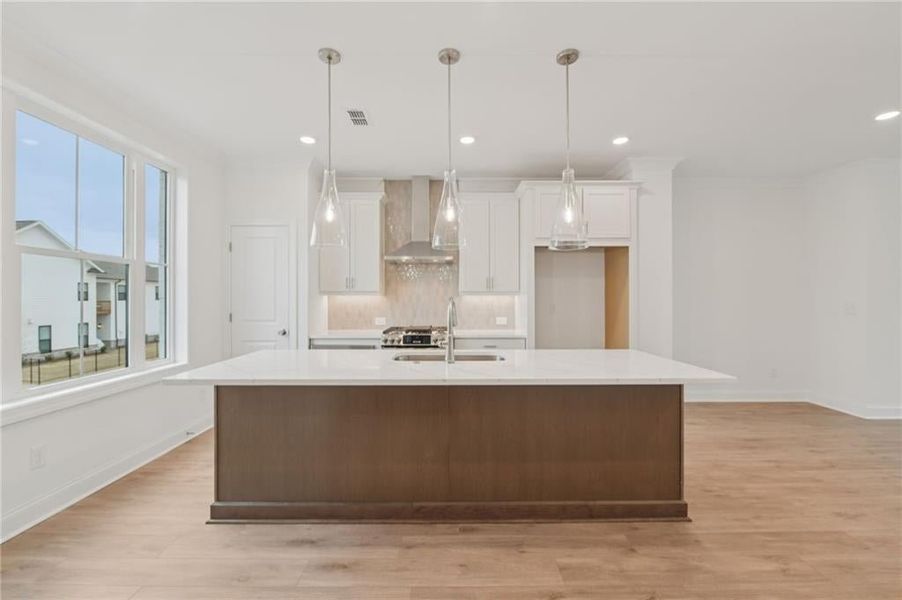 kitchen backsplash, pendent lighting over the kitchen island, plenty of seating at the island - Home is under construction and estimated to be completed in June/July 2026 
Pictures represent a previously built home not the actual home