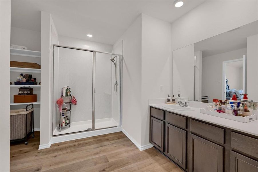 Ensuite bathroom featuring vanity, recessed lighting, connected bathroom, a stall shower, and wood finished floors