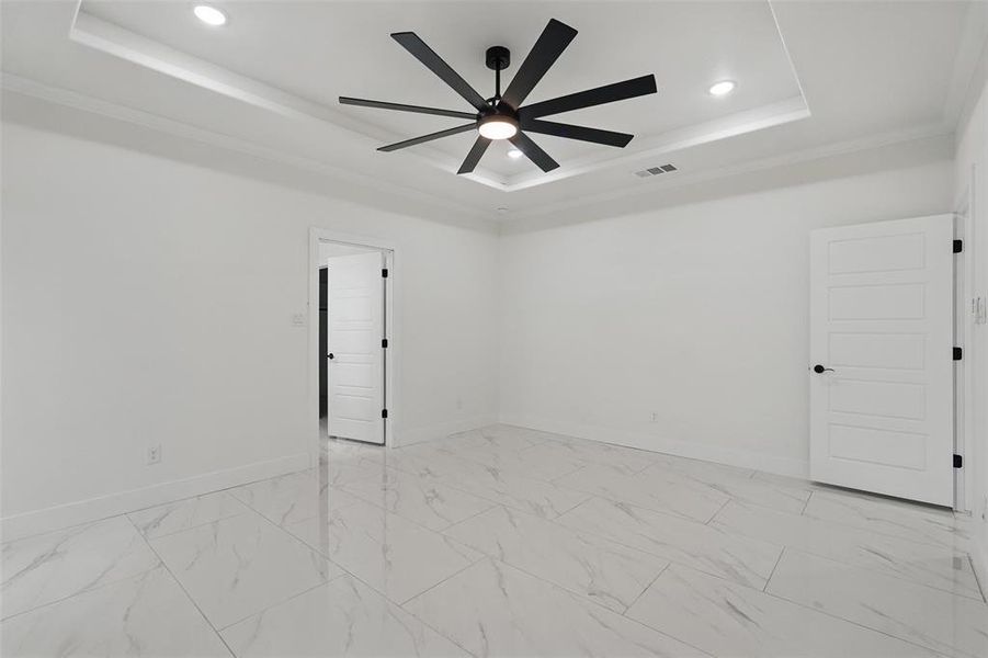 Unfurnished room featuring a raised ceiling, ceiling fan, baseboards, recessed lighting, and crown molding Unfurnished room featuring a raised ceiling, ceiling fan, baseboards, recessed lighting, and crown molding