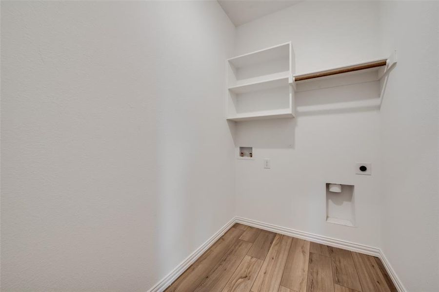 Washroom with hardwood / wood-style floors, washer hookup, and hookup for an electric dryer