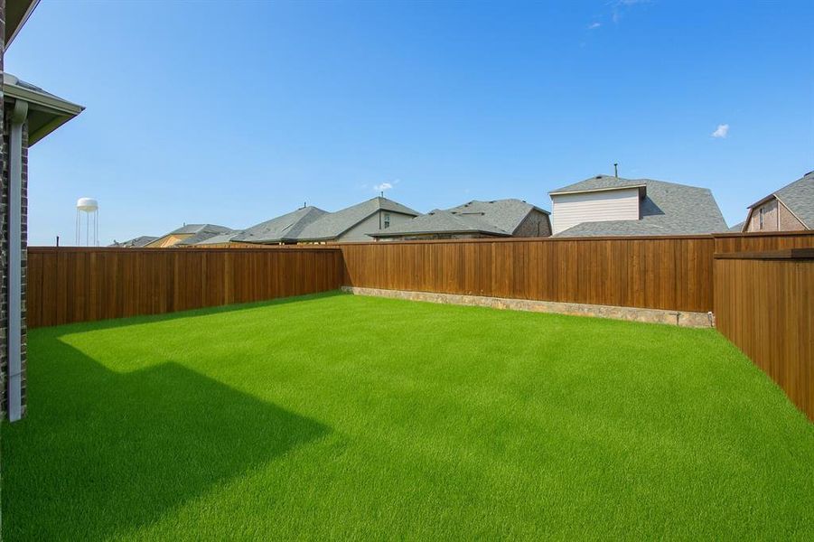 Fenced backyard with a residential view Fenced backyard with a residential view