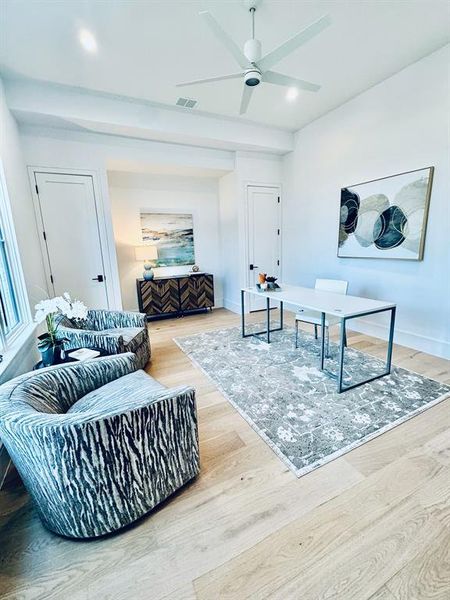 Living room with ceiling fan and light hardwood / wood-style floors