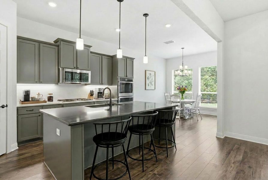 Culinary creations come to life in this kitchen featuring an island with bar seating and a connecting breakfast area. Culinary creations come to life in this kitchen featuring an island with bar seating and a connecting breakfast area.