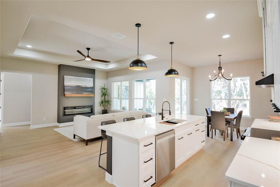 Kitchen featuring white cabinets, recessed lighting, light stone countertops, pendant lighting, and a kitchen breakfast bar Kitchen featuring white cabinets, recessed lighting, light stone countertops, pendant lighting, and a kitchen breakfast bar