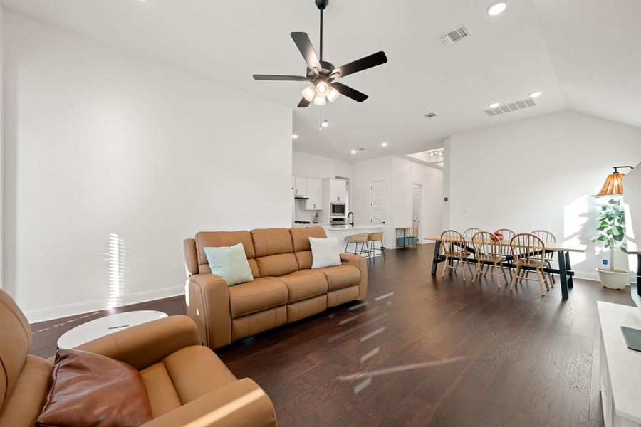 An open floorplan seamlessly connects the living area, kitchen, and dining space, all illuminated by recessed lighting and natural sun. An open floorplan seamlessly connects the living area, kitchen, and dining space, all illuminated by recessed lighting and natural sun.