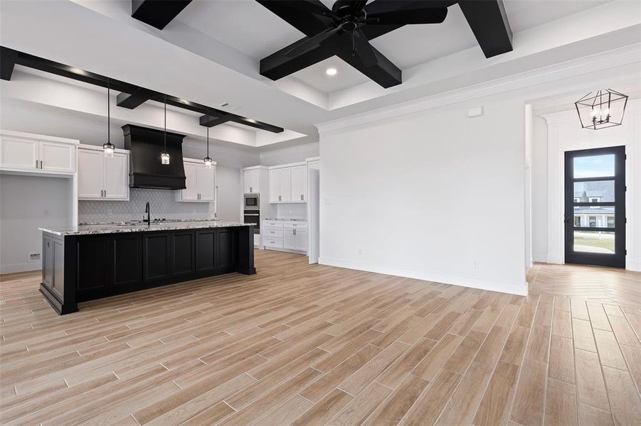 Kitchen with ceiling fan with notable chandelier, beamed ceiling, and white cabinets