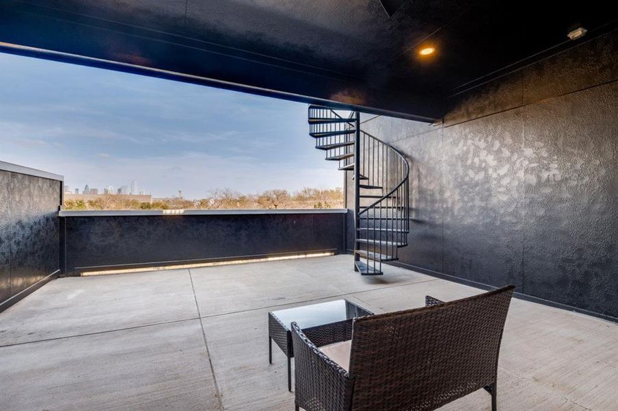 Third-floor covered patio with a ceiling fan, offering comfortable day and nighttime panoramic views of the Dallas skyline. Third-floor covered patio with a ceiling fan, offering comfortable day and nighttime panoramic views of the Dallas skyline.