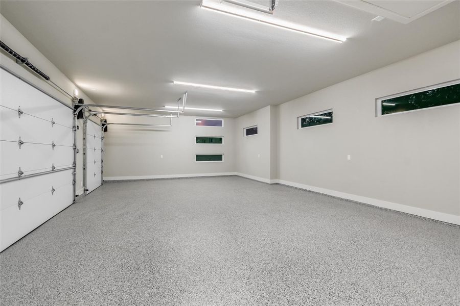 Three car garage featuring epoxy flooring and baseboards Three car garage featuring epoxy flooring and baseboards
