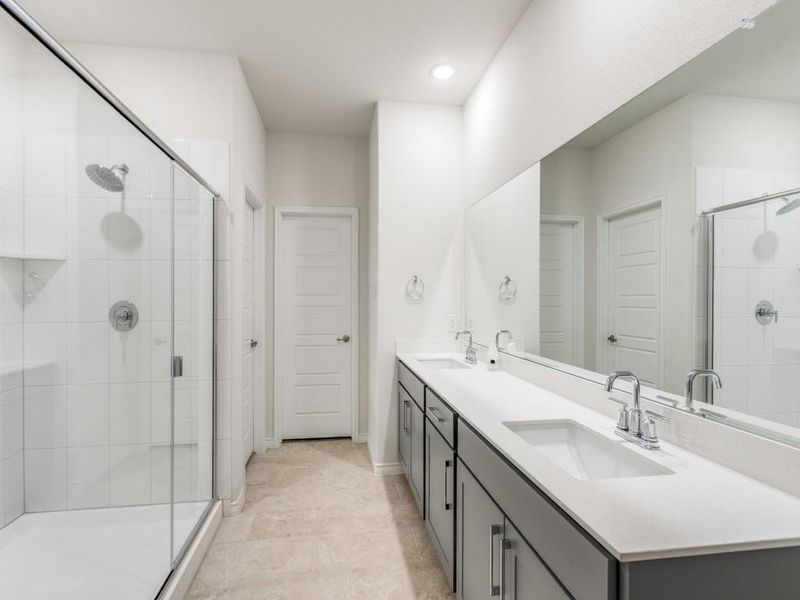 Full bath with double vanity, a stall shower, recessed lighting, and light tile patterned flooring