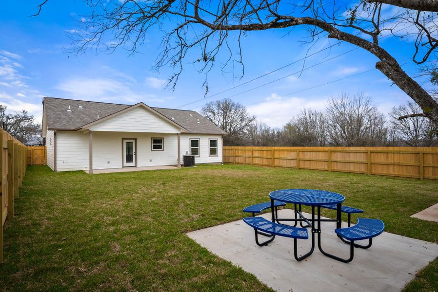 Back of house with a patio area, a fenced backyard, and roof with shingles