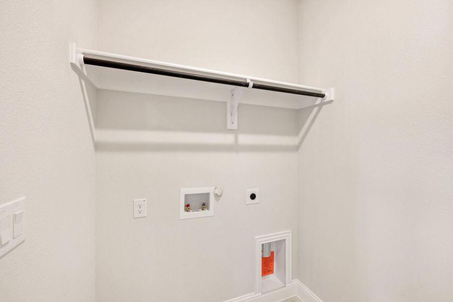Laundry room with upper shelf, hanging rod, washer hookups, and gas dryer connection on white walls