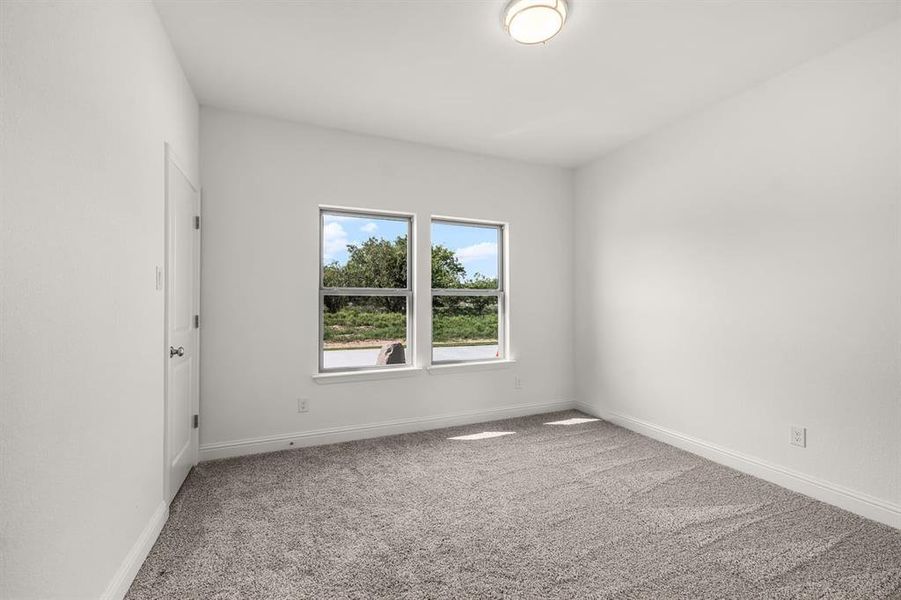Unfurnished room featuring light carpet and baseboards
