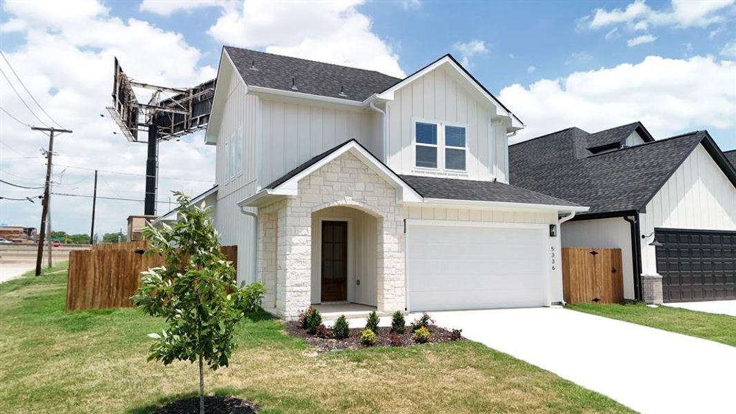 View of front facade with roof with shingles, driveway, stone siding, and board and batten siding View of front facade with roof with shingles, driveway, stone siding, and board and batten siding